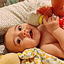 baby, infant, blanket, toy, rattle, hand, foot, face, eyes, curious, lying_down, bed, cushion, soft_toy, child, cute, indoors, skin, playful, young