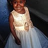 child, girl, smiling, portrait, dress, formalwear, sparkly_dress, white_dress, gold, bow, car, vehicle, outdoor, standing, curly_hair, dark_skin, happy, fashion, photography, celebration
