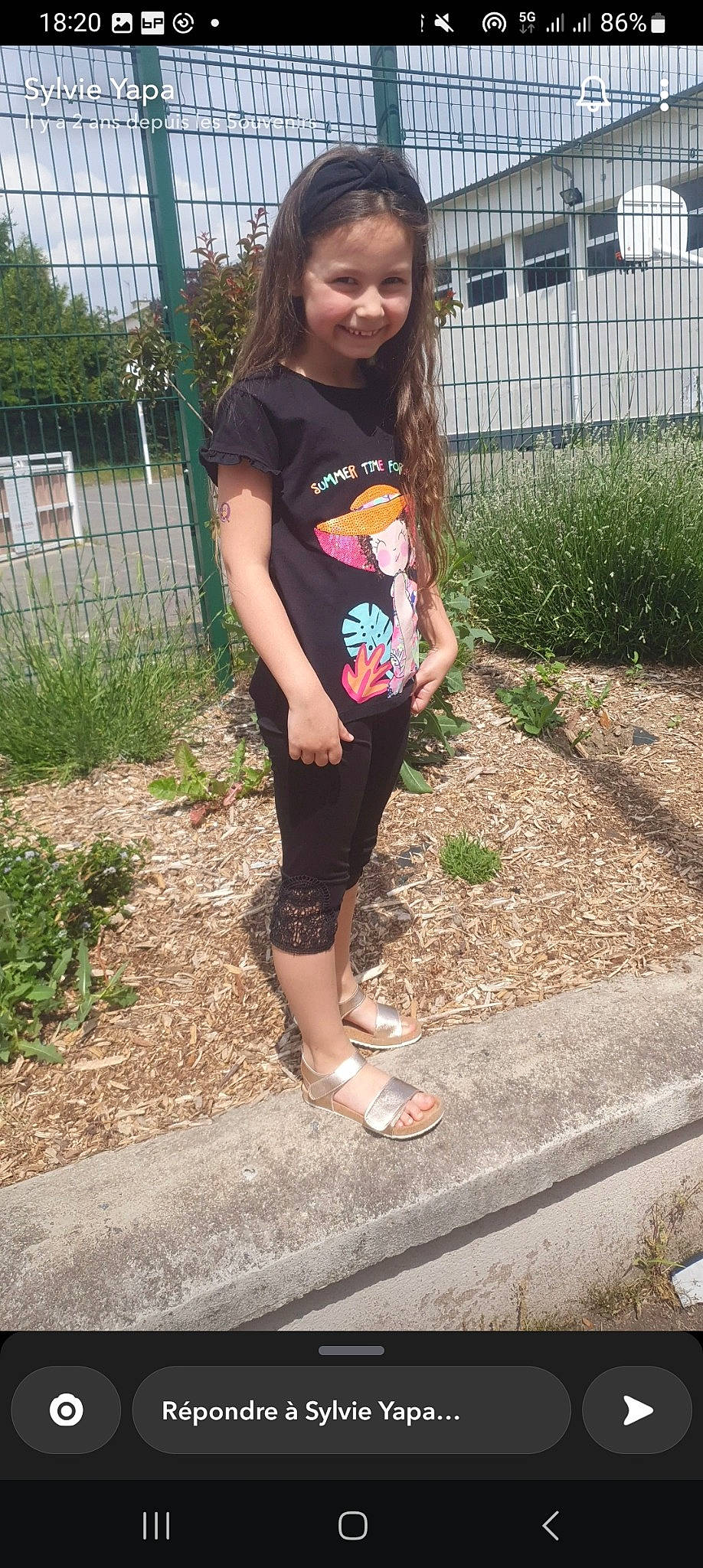 Lyna participe au concours pour gagner de l'argent avec cette photo : active_pants, fence, footwear, grass, human_leg, joy, knee, leg, long_hair, person, plant, shoe, shorts, sleeve, smile, sneakers, sportswear, t_shirt, thigh, tree