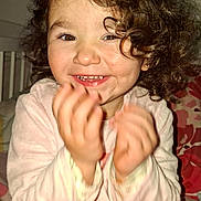 Giulia participe au concours pour gagner de l'argent avec cette photo : bed, blanket, child, clapping, cozy, curly_hair, cute, expression, face, fun, hands, happy, indoor, joy, pajamas, person, portrait, smiling, toddler, young_child