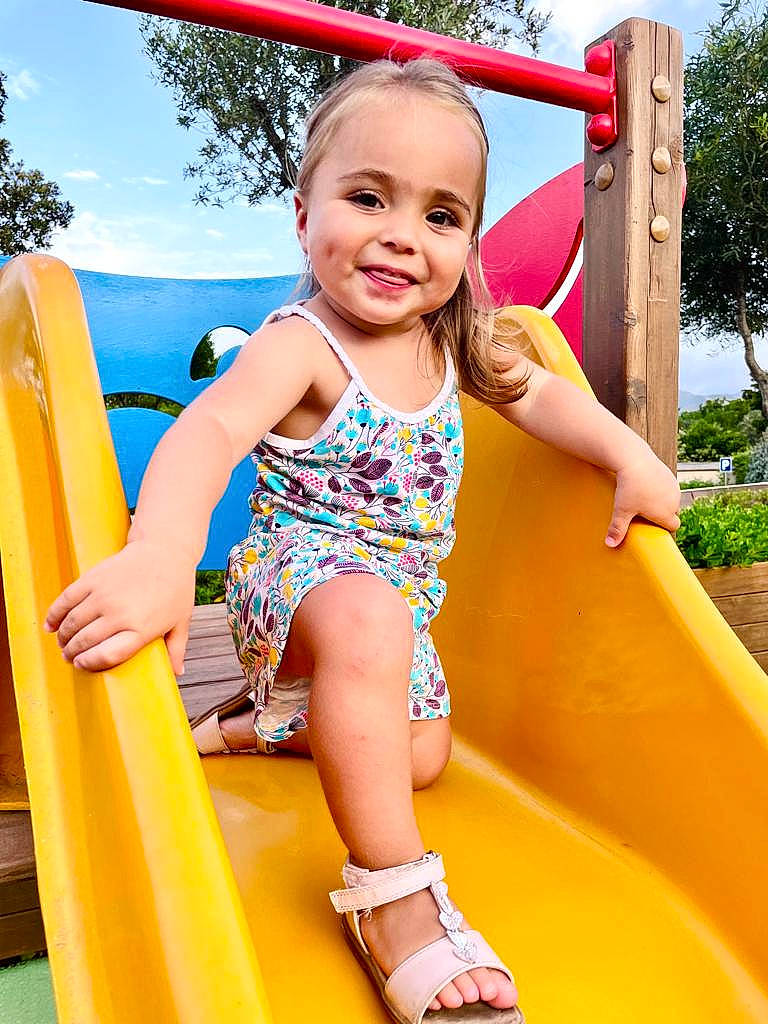 Giulia a rejoint le concours — aidez-le/la à gagner de superbes lots ! baby_toddler_clothing, chute, facial_expression, fun, grass, green, happy, joy, leg, leisure, person, playground, playground_slide, recreation, skin, sky, smile, t_shirt, thigh, toddler