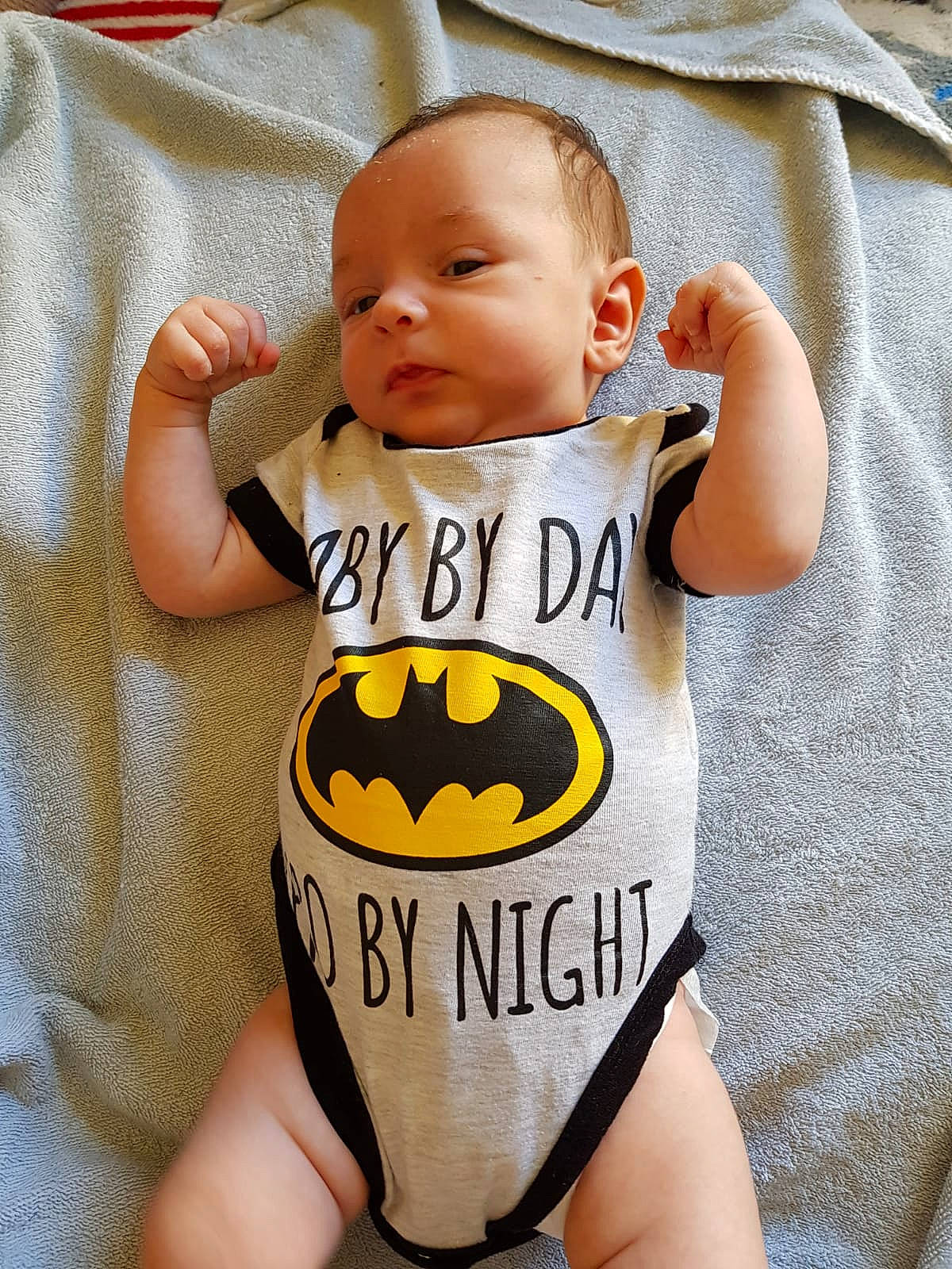 Tyam participe au concours pour gagner de l'argent avec cette photo : baby, baby_products, baby_toddler_clothing, batman, child, costume, fictional_character, infant_bodysuit, justice_league, person, product, sleeve, superhero, t_shirt, toddler, yellow