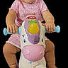 Vine is registered to the contest to win money with this photo: baby, child, toy, horse, pink_clothing, riding_toy, wheels, smiling, cute, infant, playtime, colorful, portrait, isolated, happy, hands, feet, black_background, expression, young_child