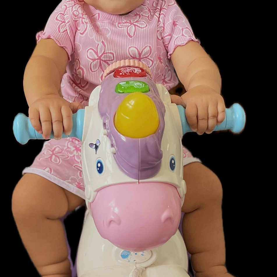 Vine is registered to the contest to win money with this photo: baby, child, toy, horse, pink_clothing, riding_toy, wheels, smiling, cute, infant, playtime, colorful, portrait, isolated, happy, hands, feet, black_background, expression, young_child