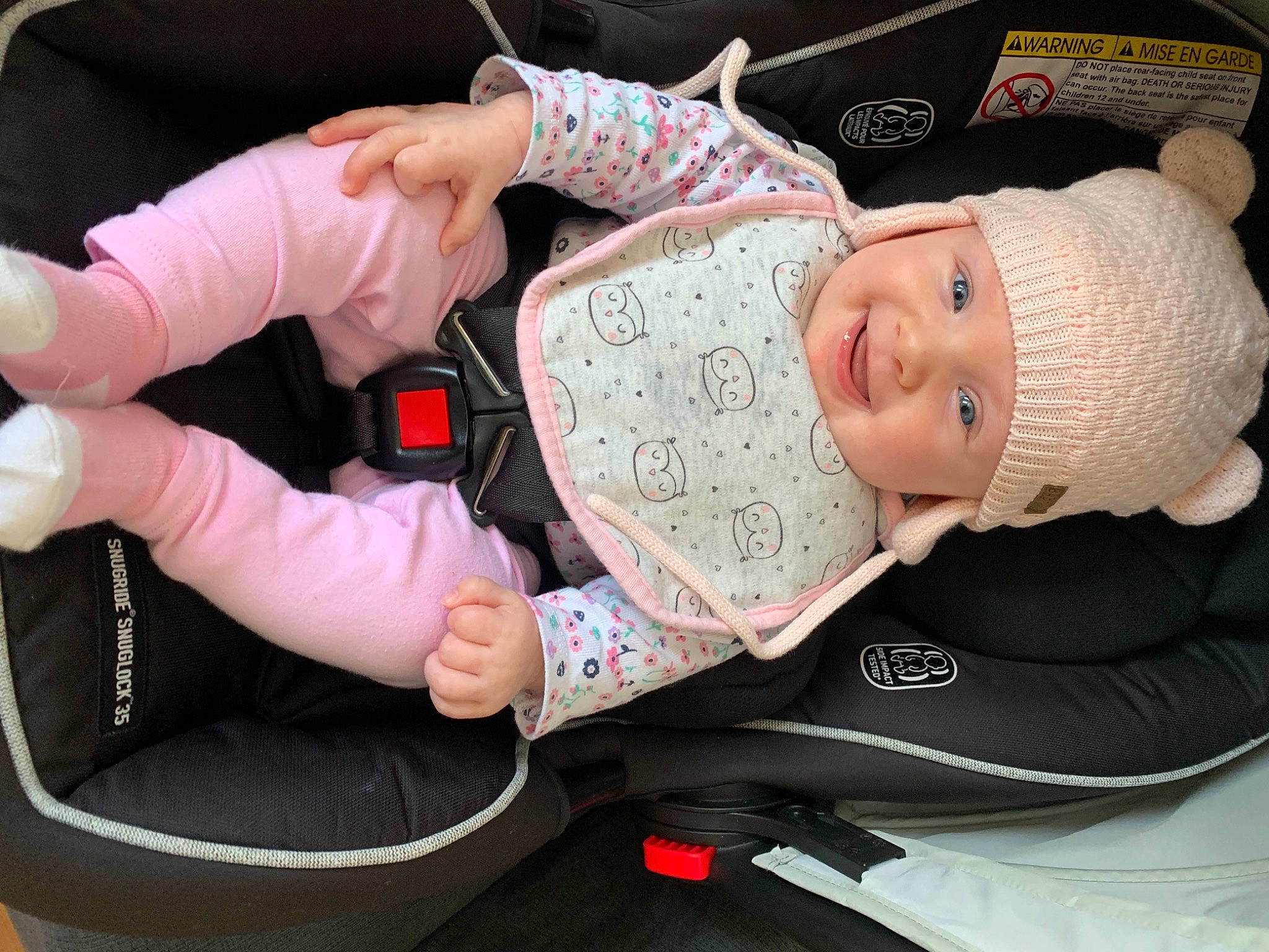 Holly is registered to the contest to win money with this photo: baby, baby_carriage, baby_products, baby_toddler_clothing, car_seat, cheek, child, comfort, eyelash, finger, hand, hat, headgear, headwear, human_body, joy, leg, nail, person, pink