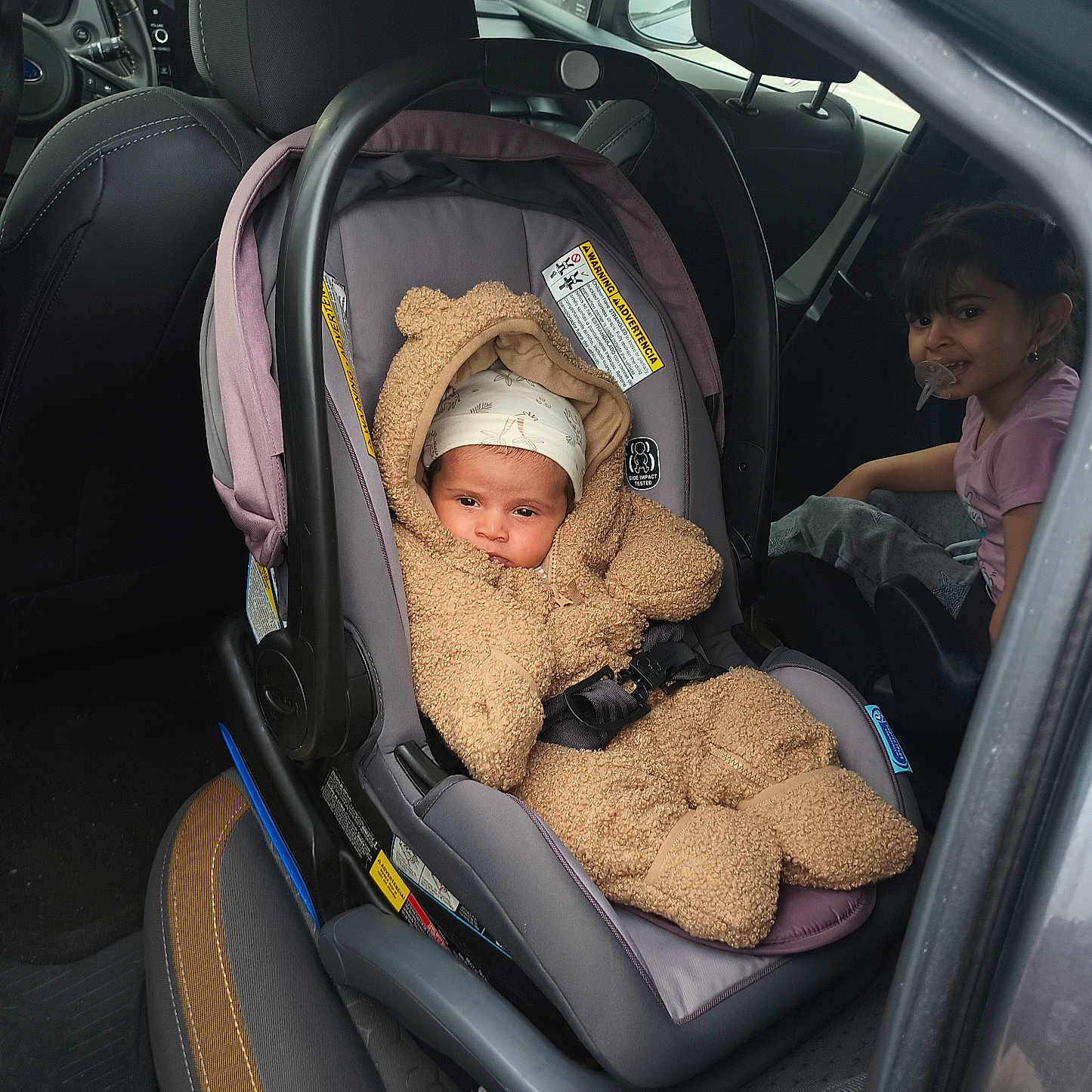 Ridah is registered to the contest to win money with this photo: automobile, baby, car_interior, car_seat, child, clothing, cute, door, family, headwear, infant, pacifier, safety, seat, seat_cover, seatbelt, smile, toddler, transportation, window