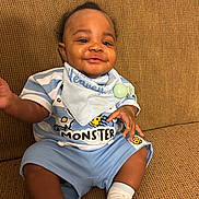 Keauri joined the competition — help win amazing prizes! baby, child, smiling, blue_clothing, striped_shirt, bib, sitting, couch, indoor, happy, infant, person, cute, sock, hand, face, portrait, comfort, young, relaxed