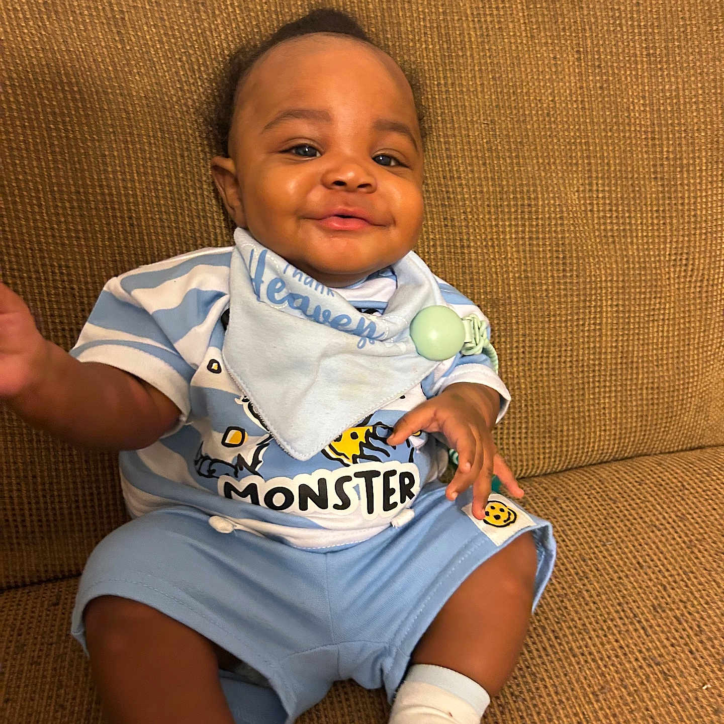 Keauri joined the competition — help win amazing prizes! baby, child, smiling, blue_clothing, striped_shirt, bib, sitting, couch, indoor, happy, infant, person, cute, sock, hand, face, portrait, comfort, young, relaxed