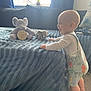 baby, child, standing, smiling, plush_toy, elephant, blanket, couch, living_room, window, curtain, carpet, clothing, infant, happy, home_interior, soft_light, toy, cute, person