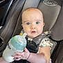 baby, milk_bottle, car_seat, graco, infant, child, seatbelt, unicorn_pattern, clothing, hand, face, eyes, expression, car_interior, seat, feeding, milk, plastic, safety, closeup