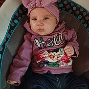 Luna is registered to the contest to win money with this photo: baby, child, headband, bow, purple_hoodie, floral_pattern, sitting, baby_seat, clothing, cute, infant, portrait, indoor, comfort, young_child, face, expression, person, casual, jeans