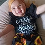 baby, child, smiling, headband, black_clothing, sunflower_pattern, cushion, indoor, cute, happy, infant, portrait, sitting, young_child, fashion, yellow, comfortable, face, person, baby_girl