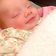 Elena joined the competition — help win amazing prizes! baby, sleeping, blanket, floral_clothing, smile, cozy, infant, face, peaceful, cute, soft_texture, indoors, child, comfort, resting, closeup, warmth, pink, white, adorable