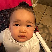 Alayah is registered to the contest to win money with this photo: toddler, child, face, eyes, white_shirt, high_chair, cosco_kids, indoor, tile_floor, curly_hair, expression, seated, clothing, baby, young_child, person, portrait, looking_up, cute, infant