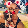 Leo is registered to the contest to win money with this photo: cute, dog, face_sticker, glasses, grass, heart_filter, holding, house, lawn, outdoors, person, portrait, puppy, selfie, sidewalk, street, sunlight, tree, woman, young_woman