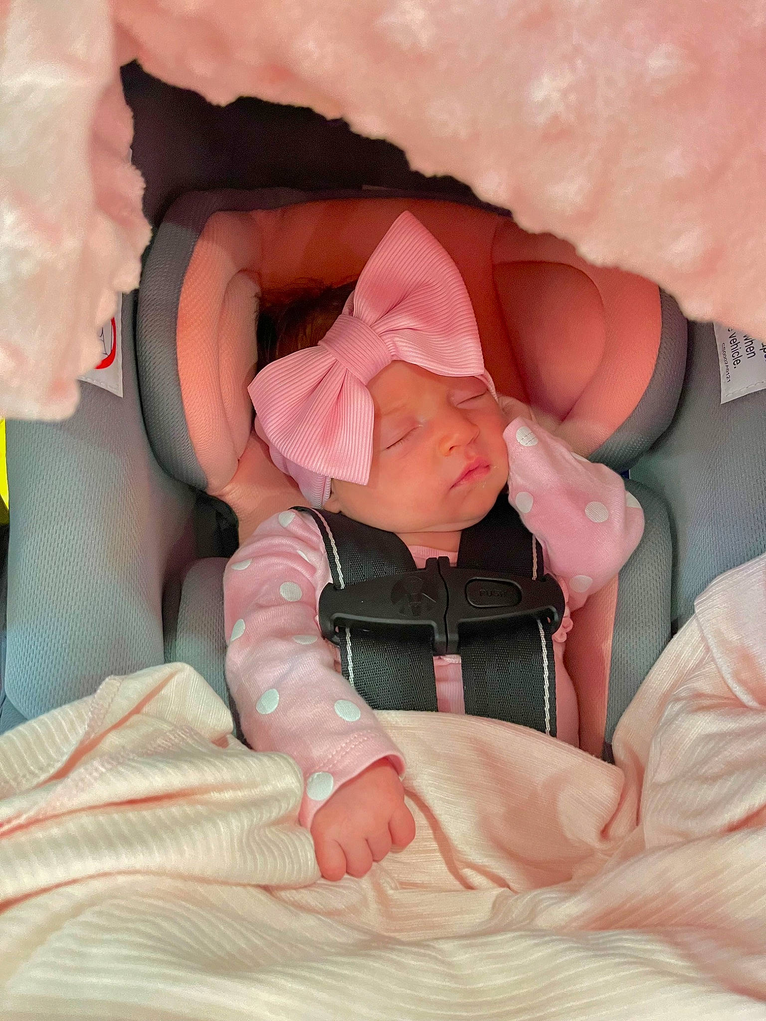 Novaleigh is registered to the contest to win money with this photo: baby, baby_toddler_clothing, bed, bedtime, carmine, comfort, finger, gesture, head, headwear, human_body, linens, nail, orange, peach, person, pink, skin, sleeve, textile