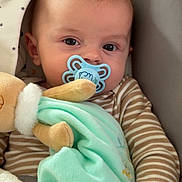 Manéo participe au concours pour gagner de l'argent avec cette photo : baby, pacifier, plush_toy, blanket, striped_clothing, infant, seated, soft_toy, cute, child, indoors, comfort, baby_seat, patterned_fabric, hand, face, head, eyes, mouth, cozy