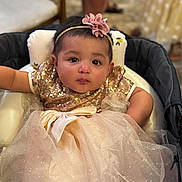 Arshiya joined the competition — help win amazing prizes! baby, child, infant, dress, sparkle, bow, headband, flower, seated, cushion, face, eyes, expression, cute, indoor, soft_focus, person, portrait, adorable, clothing