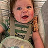 baby, bib, blue_eyes, cheeks, child, closeup, cute, elephant, expression, face, green_shirt, hair, happy, indoors, infant, patterned, seat, smiling, straps, toddler