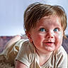 Gatlin is registered to the contest to win money with this photo: baby, background_blur, beige_clothing, blue_eyes, blush, child, closeup, crawling, curly_hair, cute, face, fluffy_rug, happy, indoor, infant, portrait, skin, smile, soft_light, toddler