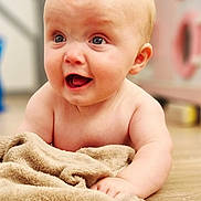 Theodore joined the competition — help win amazing prizes! baby, infant, child, blanket, floor, wooden_floor, skin, expression, face, happy, indoors, cute, portrait, young, newborn, soft_texture, hand, head, eyes, mouth