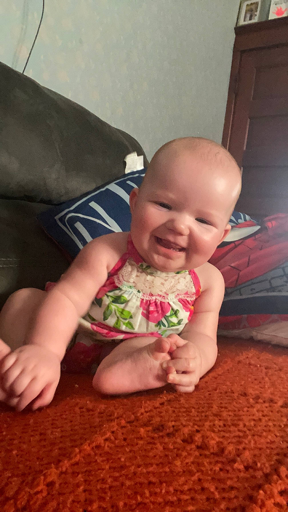 Everleigh is registered to the contest to win money with this photo: baby, baby_toddler_clothing, cheek, child, comfort, couch, finger, floor, flooring, fun, grass, happy, hardwood, human_leg, joy, person, sitting, skin, smile, thumb