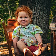 Stetson joined the competition — help win amazing prizes! child, toddler, red_hair, curly_hair, smile, bare_feet, chair, outdoor, forest, tree_trunk, patterned_shirt, pineapple_shirt, wooden_furniture, portrait, sunlight, candid, summertime, nature, happy, barefoot