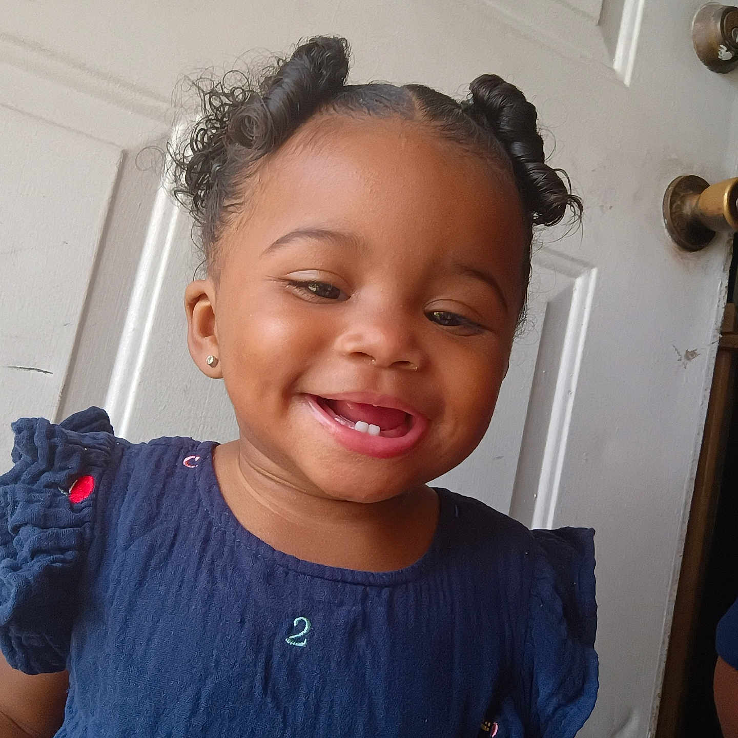 Amaiya Young joined the competition — help win amazing prizes! toddler, child, smile, happy, face, hair, dress, blue_dress, curly_hair, indoor, door, doorknob, earrings, person, portrait, cute, young_child, skin, tongue, fashion