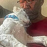 Cotton joined the competition — help win amazing prizes! man, dog, sleeping, white_dog, blue_collar, glasses, red_shirt, indoor, close_up, affection, nap, pet, friendship, relaxation, human, animal, calm, love, face, cuddle