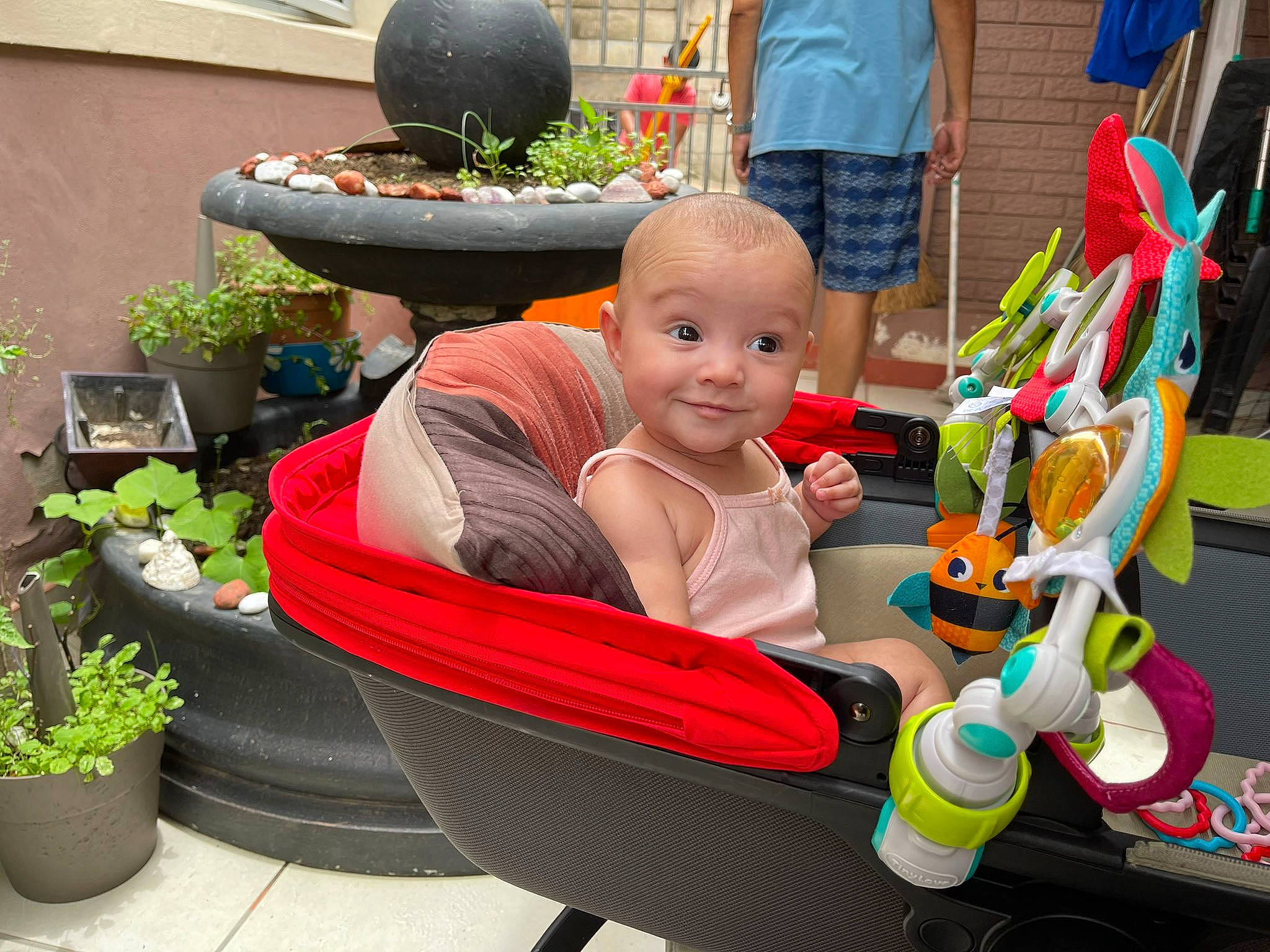 Olivia is registered to the contest to win money with this photo: baby, baby_products, child, event, flowerpot, fun, grass, green, happy, houseplant, joy, lap, leisure, person, plant, recreation, riding_toy, sitting, smile, tire