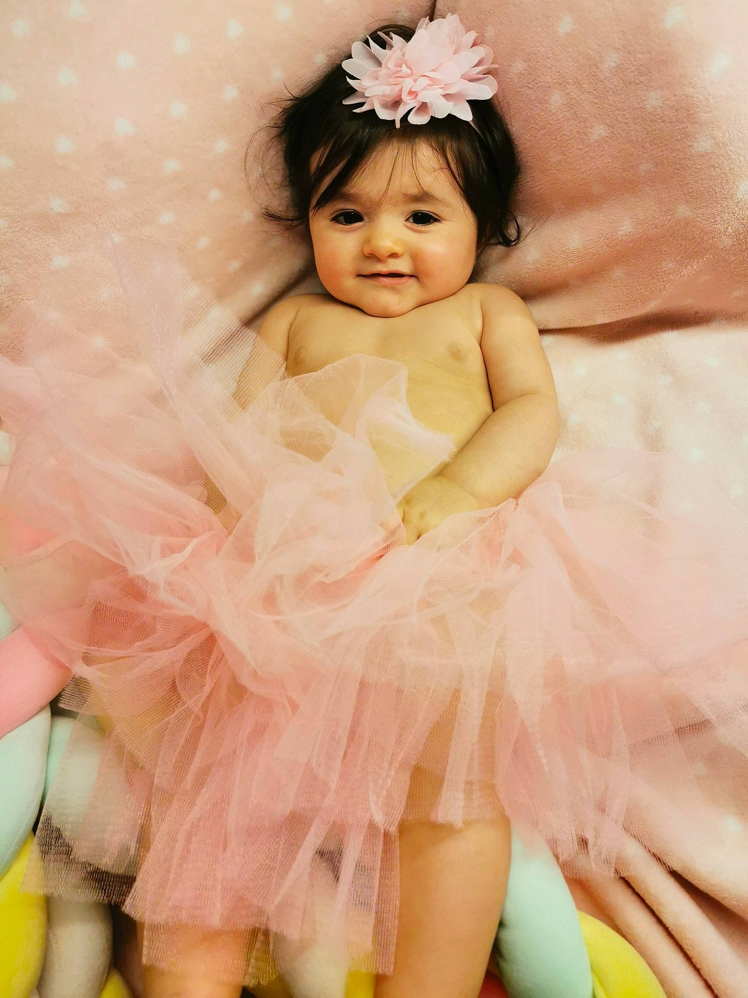 Emmy a rejoint le concours — aidez-le/la à gagner de superbes lots ! arm, baby_toddler_clothing, bridal_accessory, child, dress, embellishment, event, flash_photography, fun, happy, headband, headgear, headpiece, jewellery, joy, person, petal, pink, skin, smile