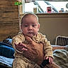 Billy joined the competition — help win amazing prizes! baby, infant, hand, tattoo, pajamas, indoor, window, curtain, person, furniture, couch, light, home, child, expression, reaching_hand, adult_hand, casual, portrait, cozy