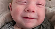 Billy is registered to the contest to win money with this photo: baby, smile, face, infant, pacifier, clothing, cushion, pattern, closeup, portrait, sleepy, cozy, happy, child, person, indoors, soft, blanket, apparel, cute