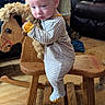 baby, child, rocking_horse, wooden_toy, striped_onesie, indoor, floor, person, furniture, leather_chair, toy, play, cute, young_child, wood, flooring, clothing, living_room, seated, contemplative