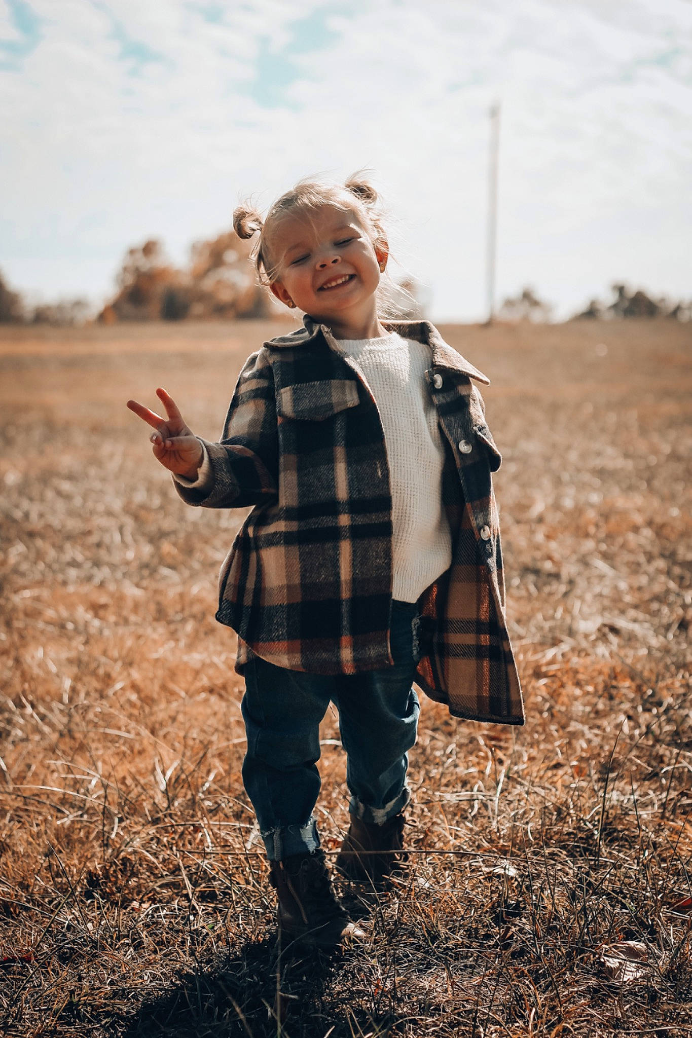 Leighton is registered to the contest to win money with this photo: eye, flash_photography, gesture, grass, grassland, hand, happy, human_body, joy, leaf, people_in_nature, person, plaid, plant, sky, sleeve, standing, sunlight, tartan, toddler