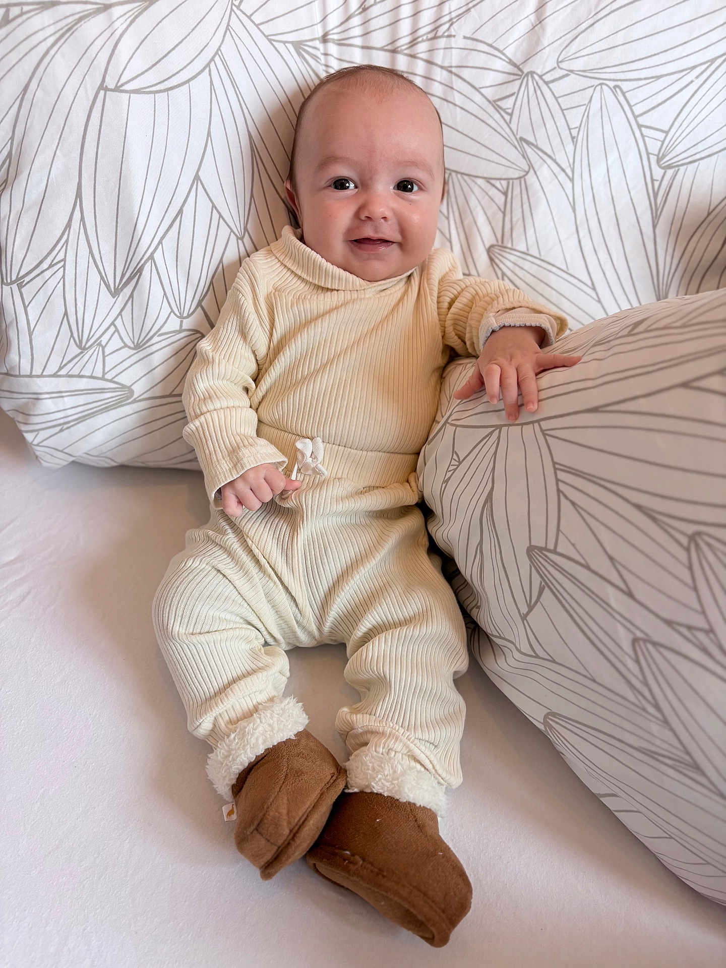 Owenn participe au concours pour gagner de l'argent avec cette photo : baby, infant, smiling, pajamas, booties, sitting, pillow, bed, blanket, cozy, indoor, child, cute, portrait, face, person, soft_lighting, pattern, comfort, warm_clothing