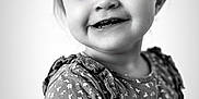 Mencïa participe au concours pour gagner de l'argent avec cette photo : child, toddler, portrait, black_and_white, smiling, happy, face, eyes, clothing, dress, flower_pattern, young, cute, person, head, hair, indoors, expression, baby, closeup