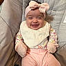 Amila is registered to the contest to win money with this photo: baby, baby_seat, bib, bow, child, cushion, cute, cute_expression, fabric, flower_pattern, happy, headband, indoors, infant, mittens, pink_clothing, portrait, sitting, smiling, soft_lighting