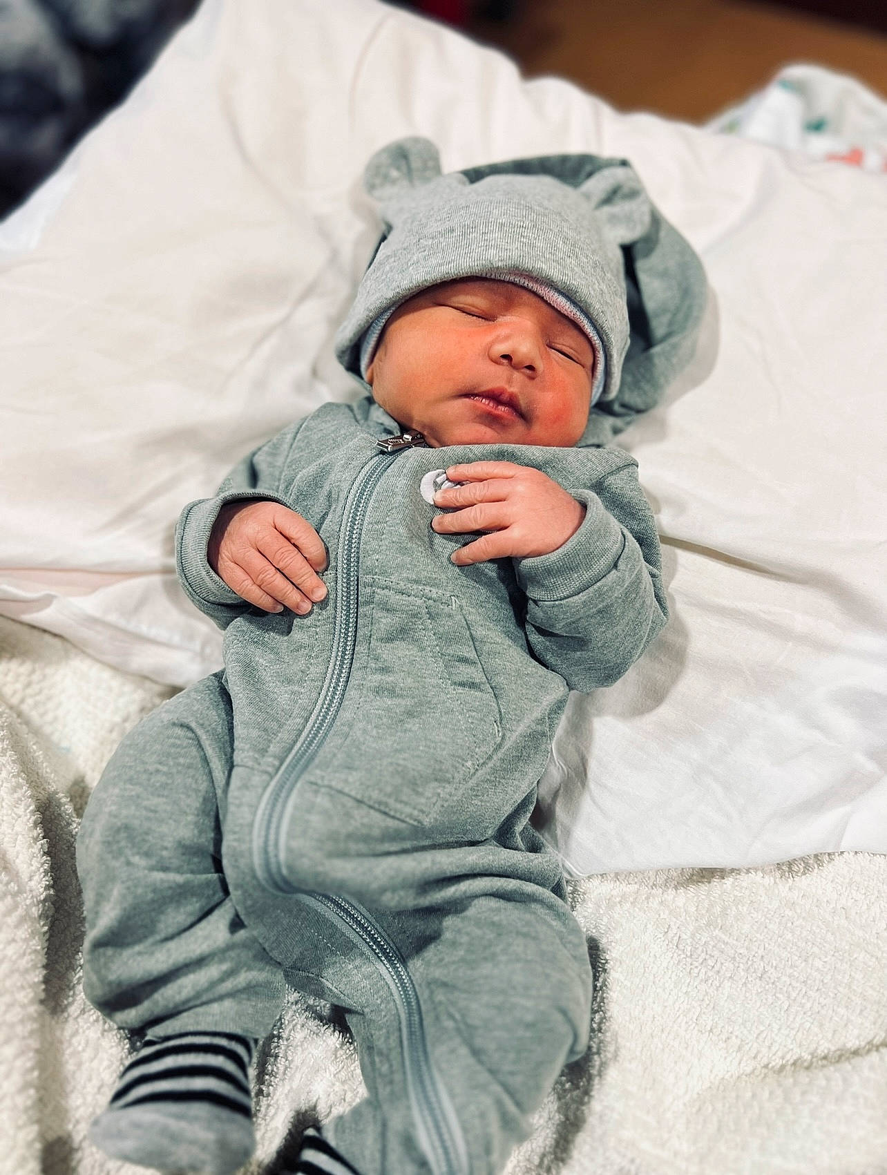 Andrés is registered to the contest to win money with this photo: baby, baby_sleeping, baby_toddler_clothing, beanie, cap, cheek, child, comfort, freezing, fur, gesture, happy, headwear, hoodie, hug, knit_cap, linens, person, sleeve, toddler
