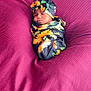 baby, sleeping, swaddled, headband, flower_pattern, sunflower, blanket, magenta, texture, cozy, infant, cute, portrait, resting, soft, peaceful, child, wrapped, indoor, newborn