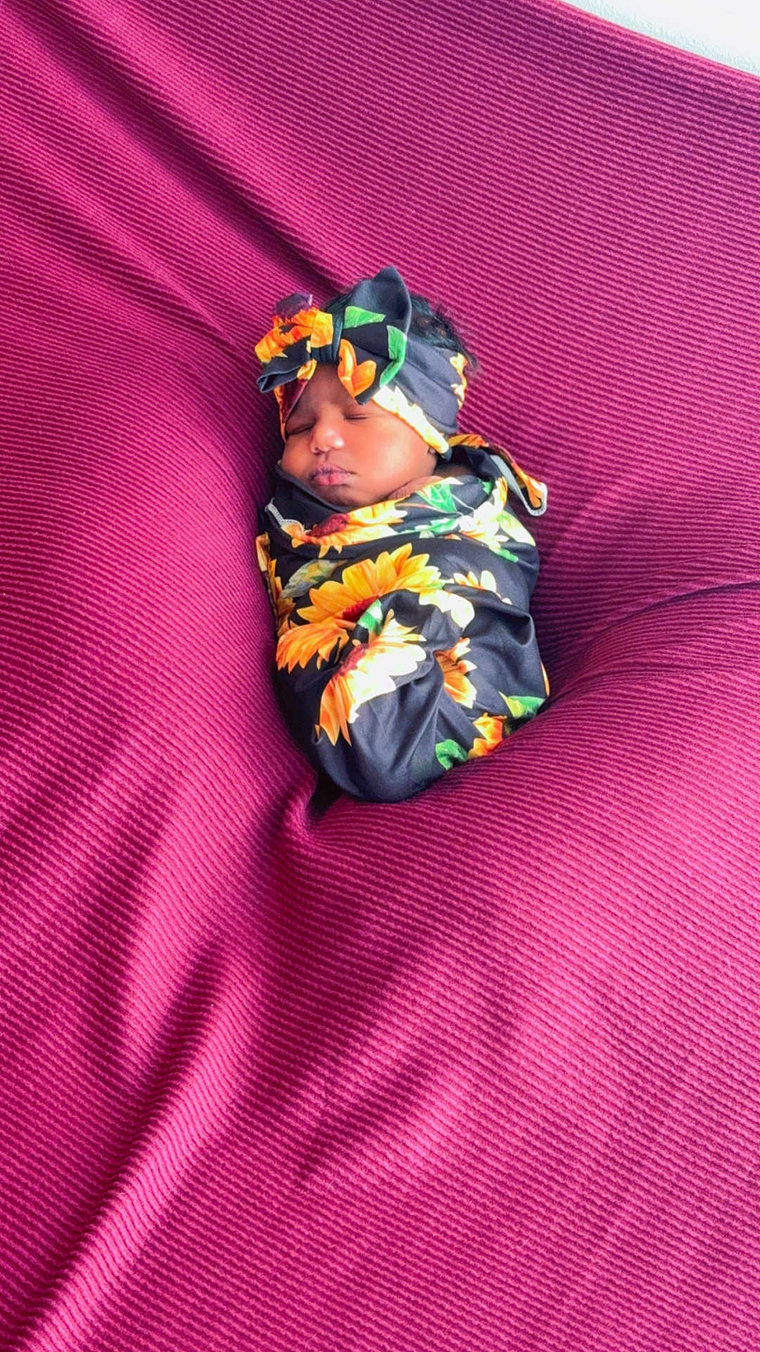 Esharie Owens joined the competition — help win amazing prizes! baby, sleeping, swaddled, headband, flower_pattern, sunflower, blanket, magenta, texture, cozy, infant, cute, portrait, resting, soft, peaceful, child, wrapped, indoor, newborn