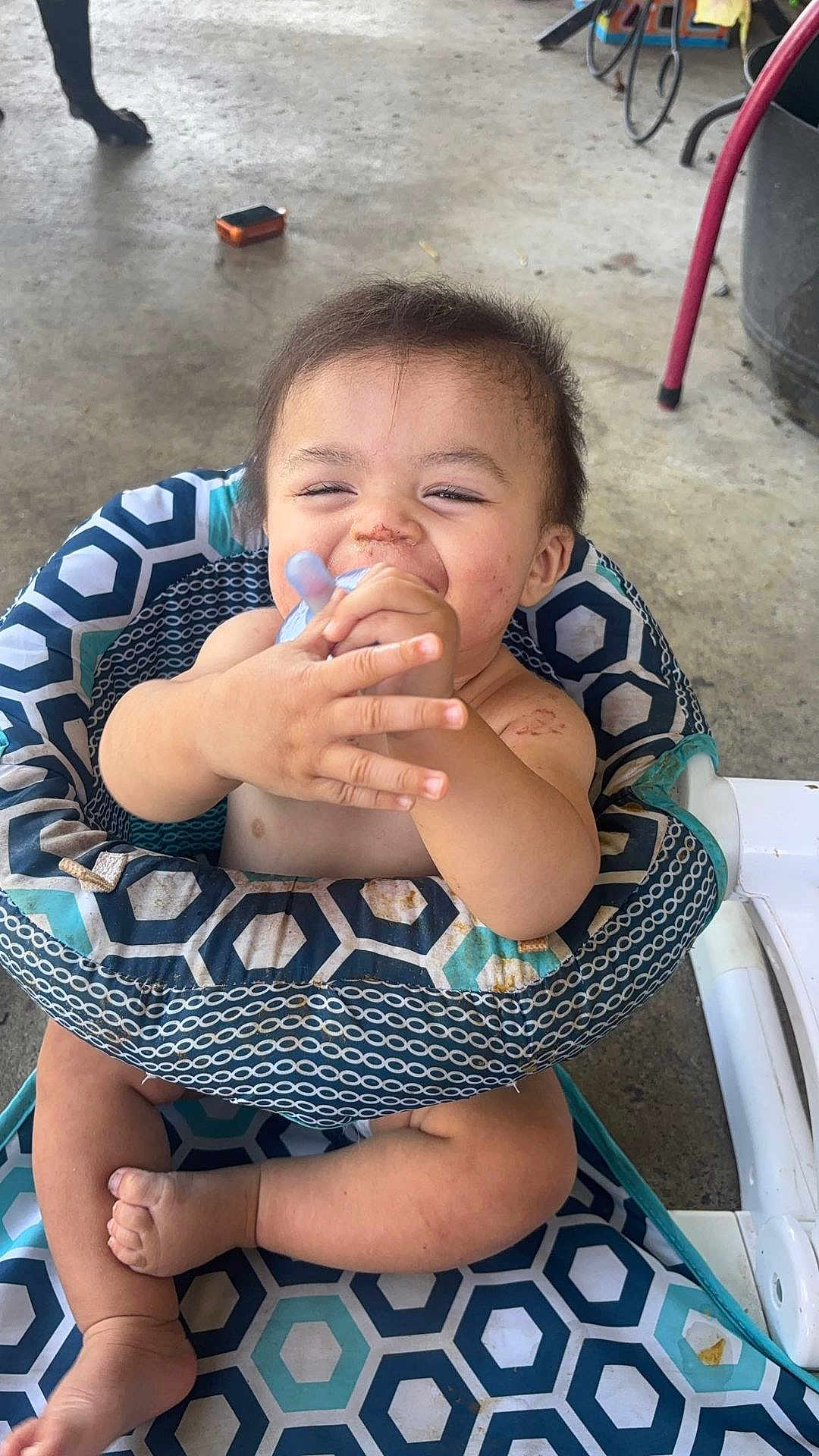 Houston joined the competition — help win amazing prizes! baby, infant, bottle, sitting, high_chair, patterned_fabric, happy, smiling, dirty_face, bare_chest, barefoot, indoor, concrete_floor, toys, child, cute, young, person, playful, feeding