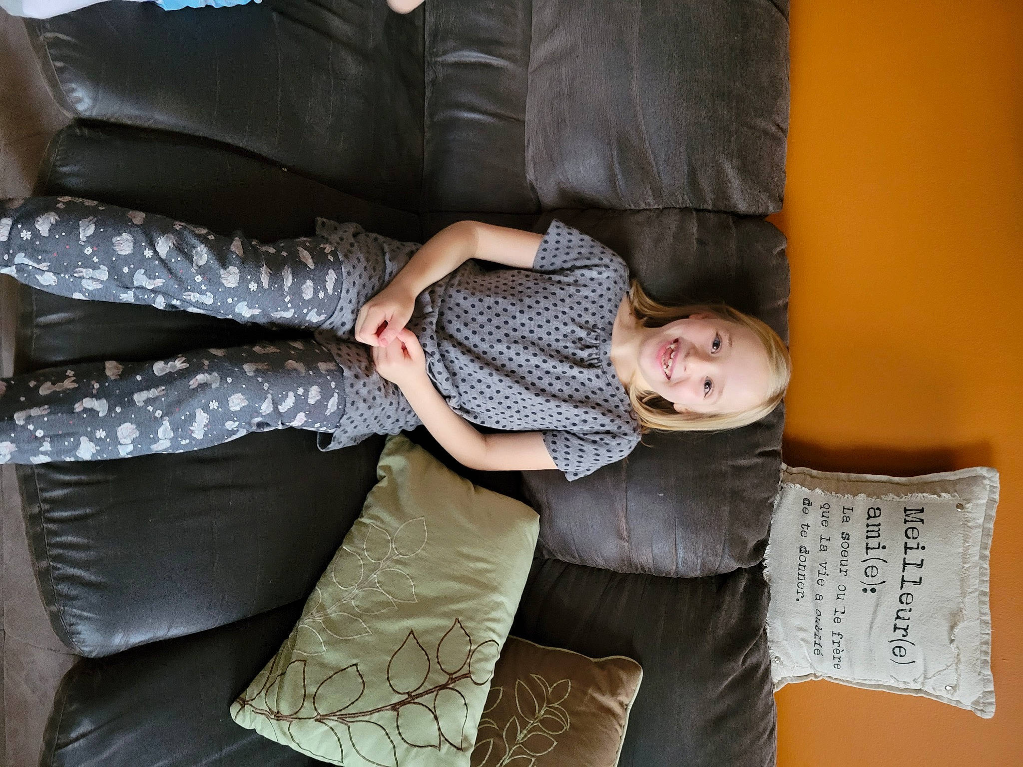 Melody participe au concours pour gagner de l'argent avec cette photo : comfort, couch, facial_expression, finger, flooring, fun, hairstyle, human_leg, joint, joy, knee, lap, leg, linens, living_room, pattern, person, room, sitting, sock