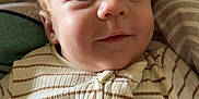 Illyano a rejoint le concours — aidez-le/la à gagner de superbes lots ! baby, infant, face, portrait, clothing, striped_onesie, curly_hair, eyes, skin, blanket, soft, cute, lying_down, child, young, person, indoors, comfortable, closeup, expression