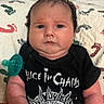 Dean is registered to the contest to win money with this photo: baby, infant, child, portrait, lying_down, pacifier, black_shirt, band_shirt, alice_in_chains, music, rock, blanket, patterned_blanket, milestone_blanket, indoor, close_up, face, serious_expression, dark_hair, hands
