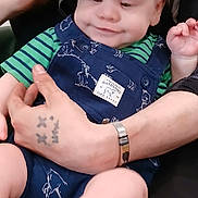 Heston joined the competition — help win amazing prizes! baby, child, infant, overalls, hat, camo, striped_shirt, hand, tattoo, wristwatch, smile, sitting, cute, person, clothing, indoor, comfort, skin, face, arm