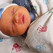 Asher-Hazen Acob is registered to the contest to win money with this photo: newborn, baby, sleeping, blanket, hat, hospital, bassinet, infant, cute, wrapped, peaceful, face, child, baby_clothes, blue, white, pattern, soft, resting, small