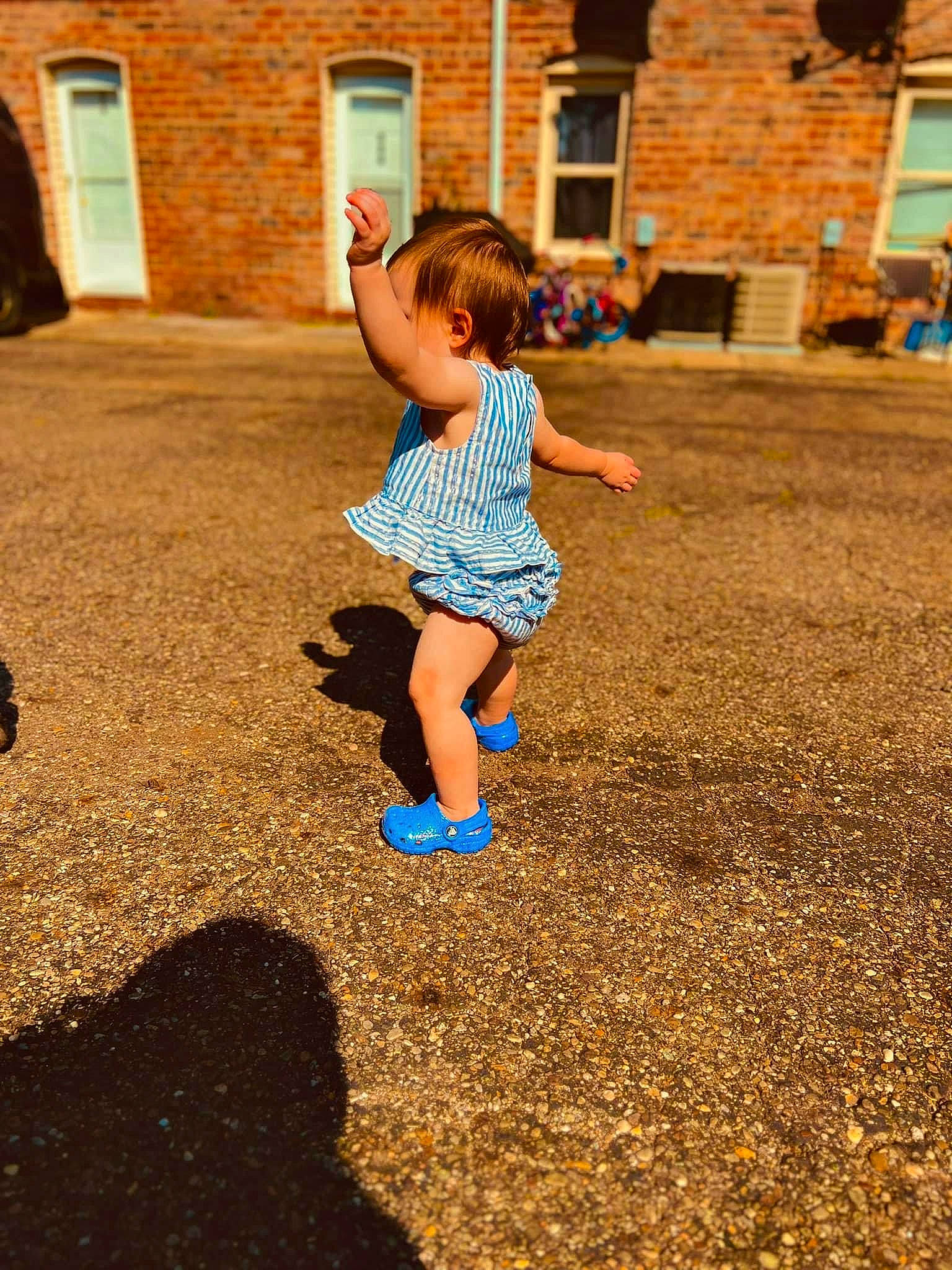 Gianna is registered to the contest to win money with this photo: asphalt, child, city, electric_blue, flooring, fun, grass, happy, human_leg, landscape, leisure, people_in_nature, person, recreation, road_surface, sitting, soil, t_shirt, tints_and_shades, toddler