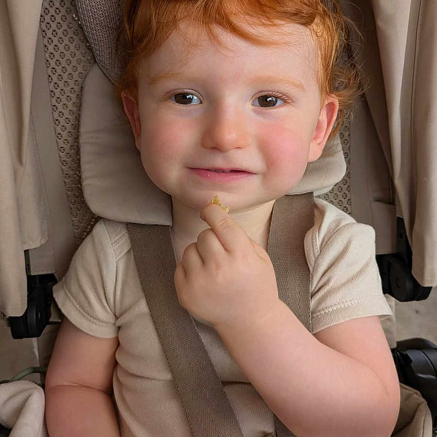 Sandro a rejoint le concours — aidez-le/la à gagner de superbes lots ! baby, beige, child, clothing, curly_hair, cute, face, hand, headrest, indoor, person, portrait, red_hair, seat, seatbelt, smile, snack, stroller, toddler, young_child