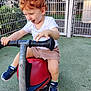 toddler, child, playground, spring_rocker, curly_hair, red_hair, white_shirt, shorts, sneakers, marvel, play, outdoor, fence, greenery, happy, tongue_out, fun, summer, daylight, toy